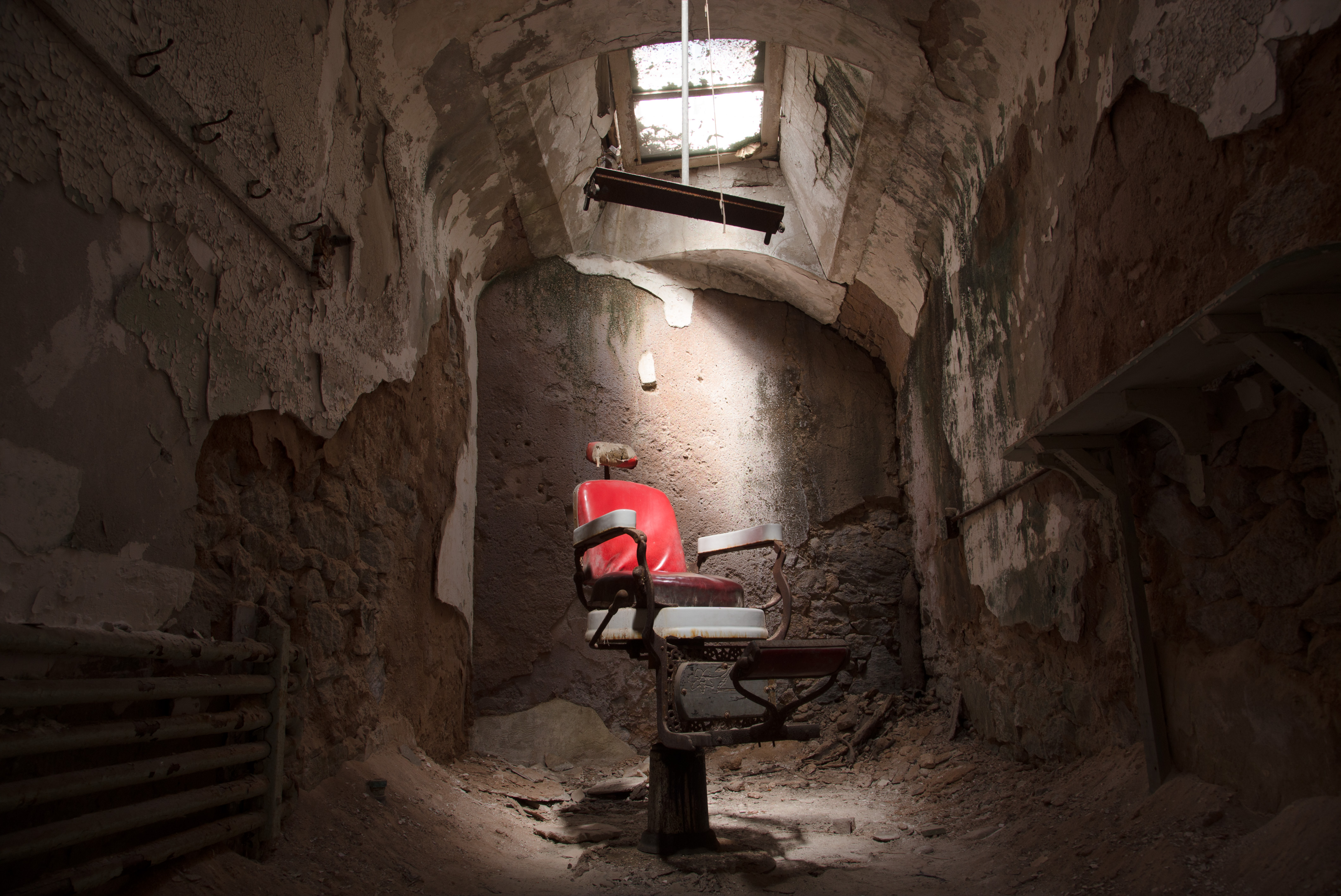 A picture of an empty chair in a prison cell